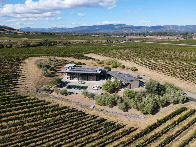 a view of a patio with dining table and chairs with a floor to ceiling window