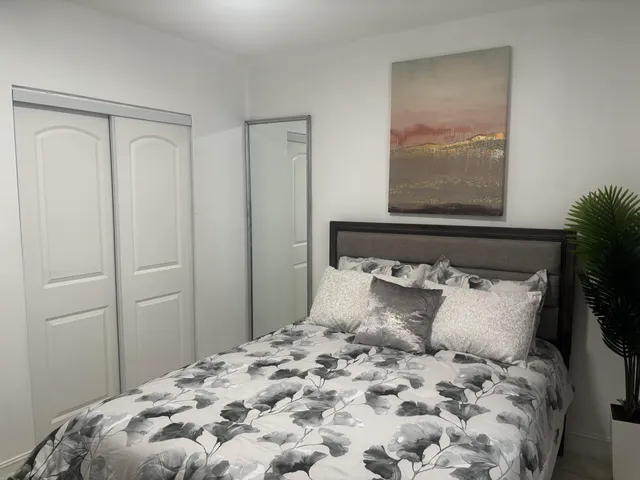 a large bed sitting in a bedroom next to a window