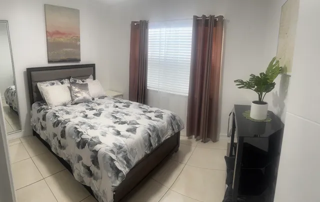 a bedroom with a bed and a potted plant