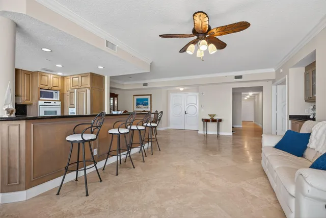 a dining room with furniture a chandelier and kitchen view