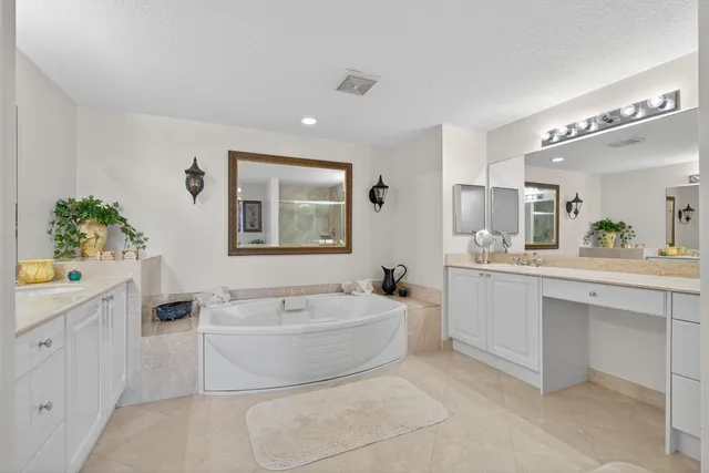 a spacious bathroom with a bathtub a sink and a mirror