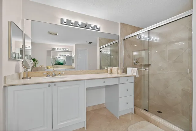 a bathroom with a shower sink and mirror
