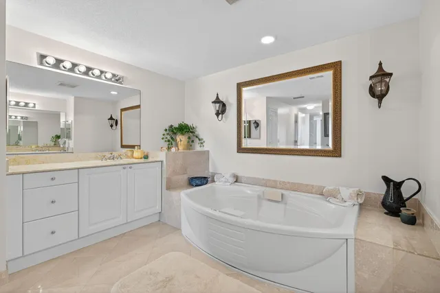 a spacious bathroom with a tub sink and mirror
