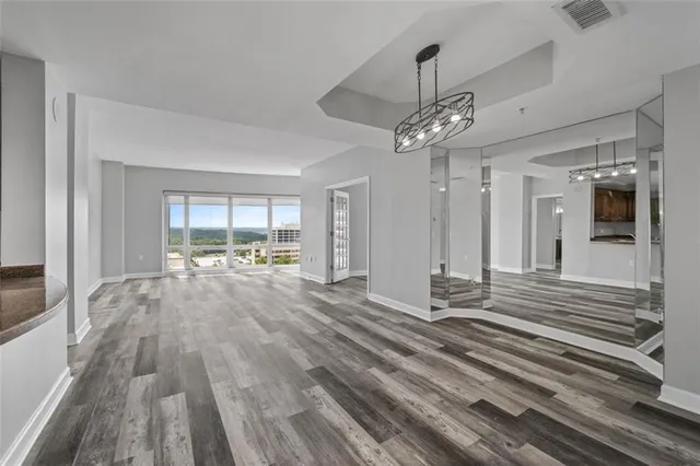 a view of a hallway with wooden floor and chandelier
