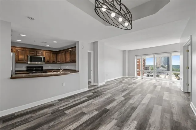 a open kitchen with stainless steel appliances granite countertop a refrigerator and microwave