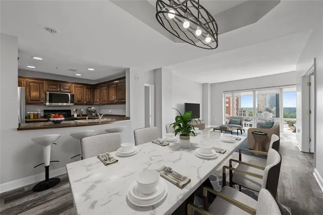 a view of a dining room with furniture a kitchen and chandelier