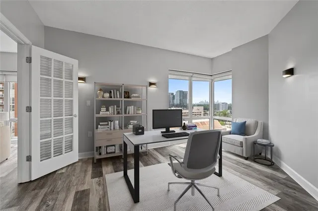 a view of a workspace with furniture and a window