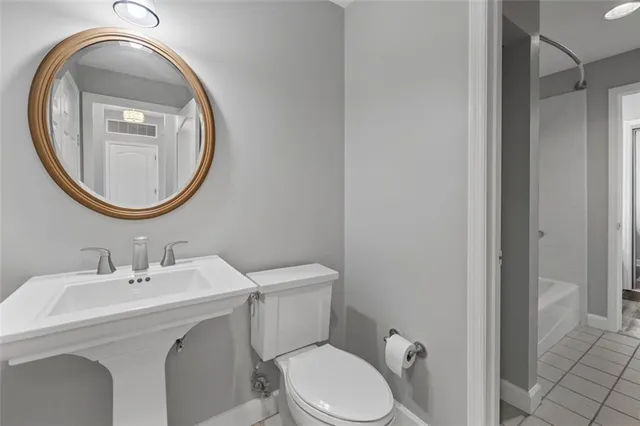 a bathroom with a toilet a sink and mirror