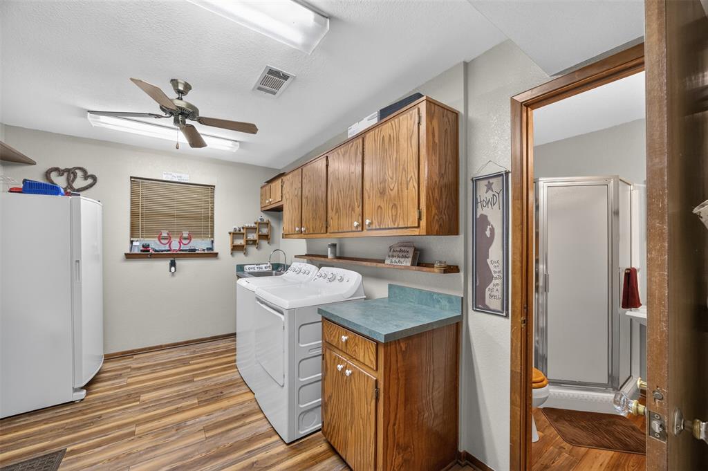 10964 River Ranch Road Kemp, TX 75143 - Photo 22 of 40 Wood-finish flooring throughout, ceiling fan with integrated lighting, and wood cabinetry offering ample storage