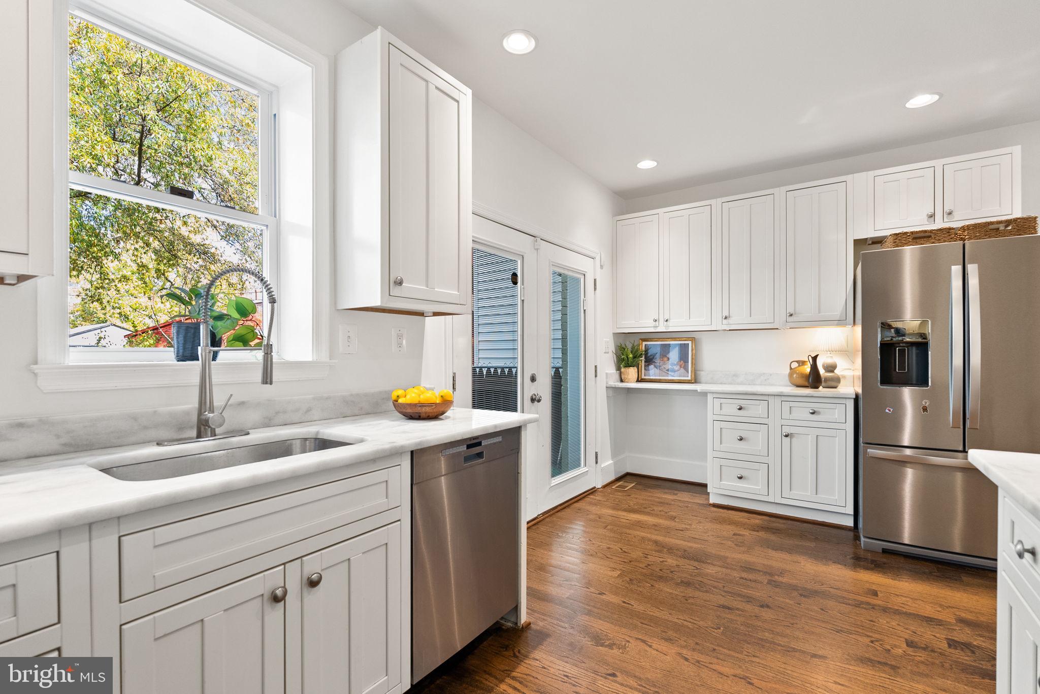 113 Hamilton Street Northwest Washington, DC 20011 - Photo 7 of 24 a kitchen with a sink wooden floor and stainless steel appliances