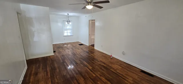 a view of wooden floor and a chandelier fan in a room