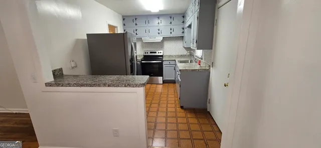 a kitchen with stainless steel appliances granite countertop a refrigerator and a stove