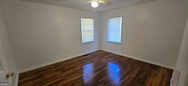 wooden floor in an empty room with a window