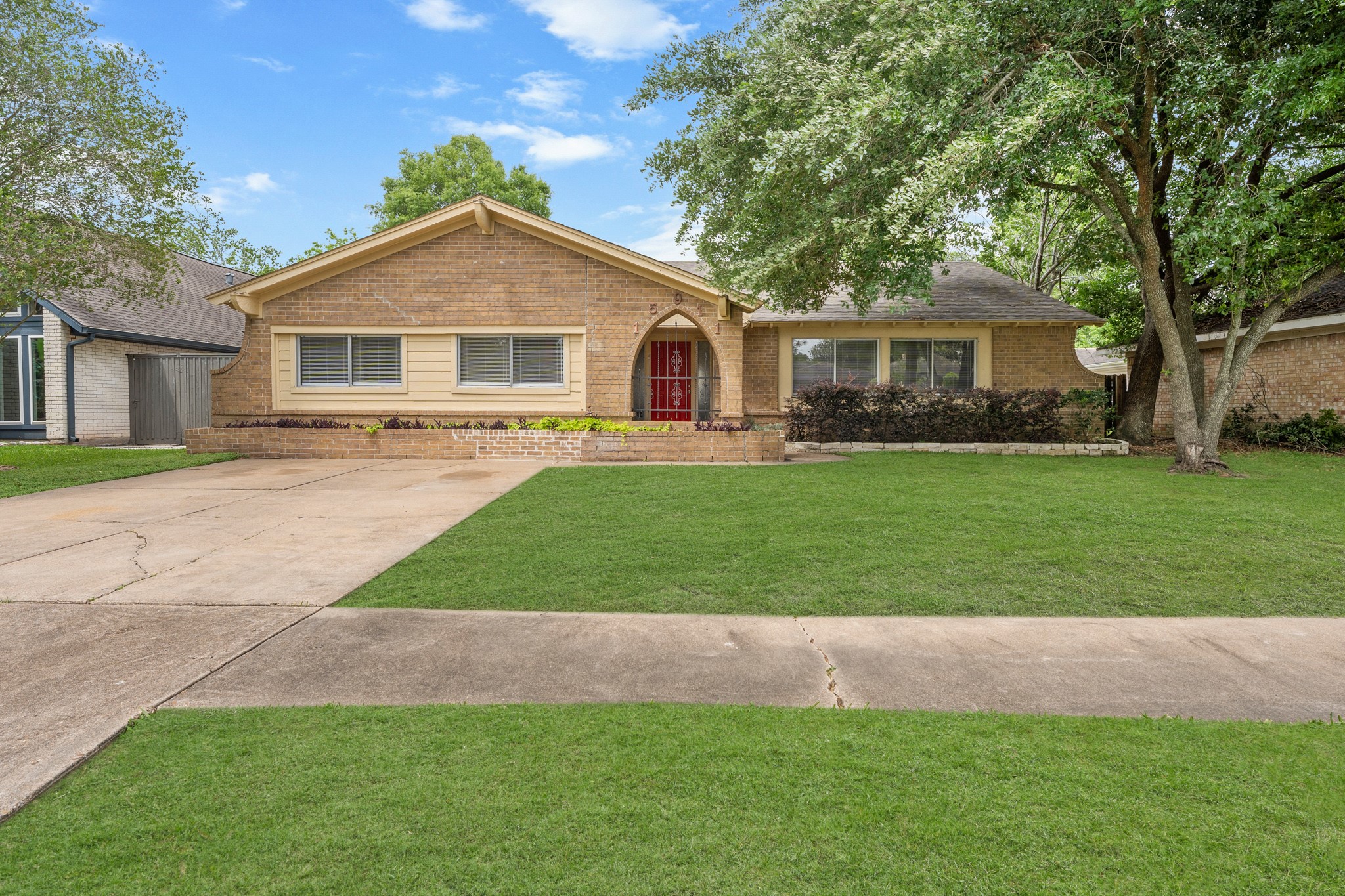 a front view of a house with a garden and trees