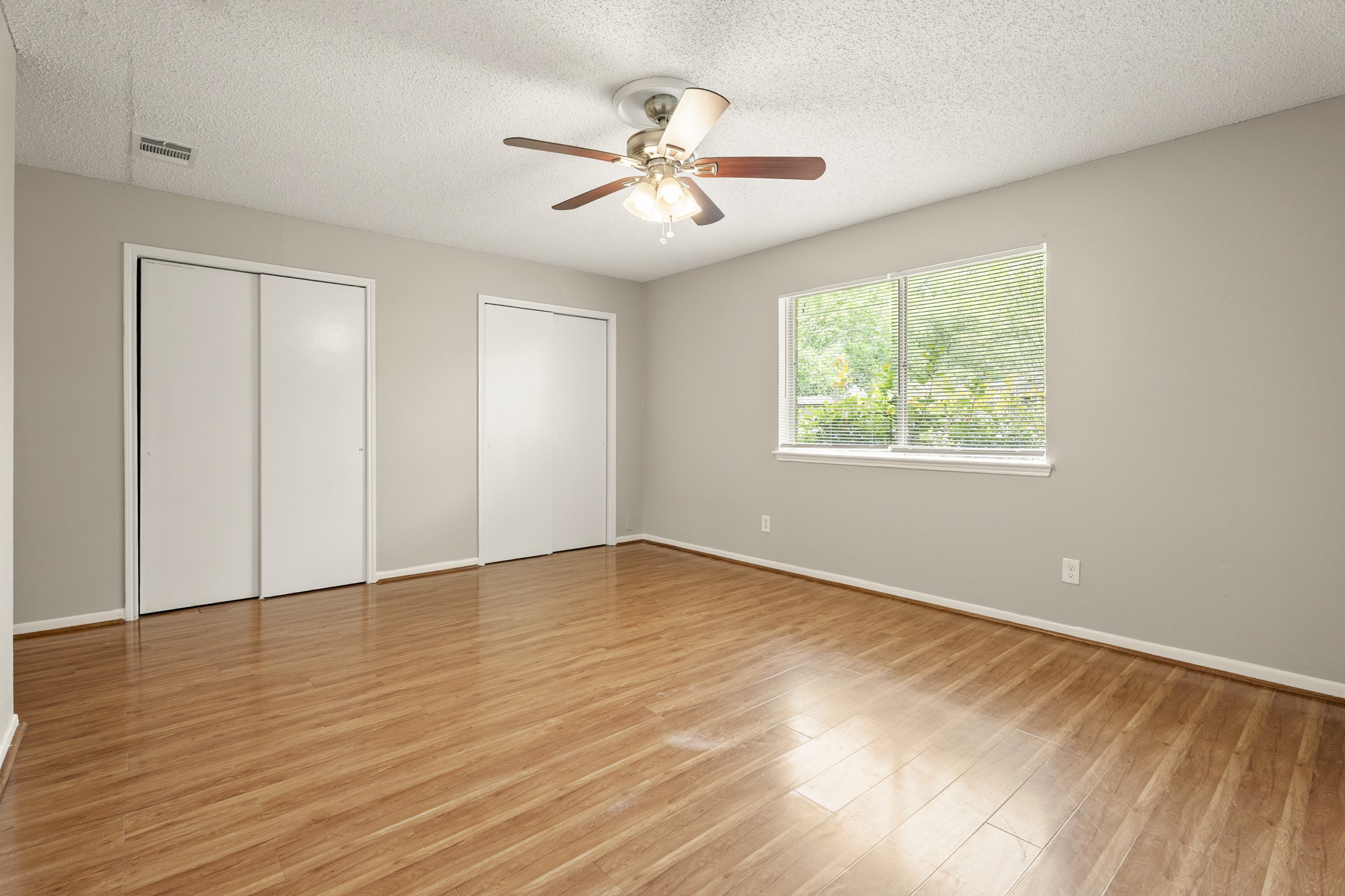 15911 Mill Point Drive Houston, TX 77059 - Photo 14 of 16 an empty room with wooden floor chandelier fan and windows