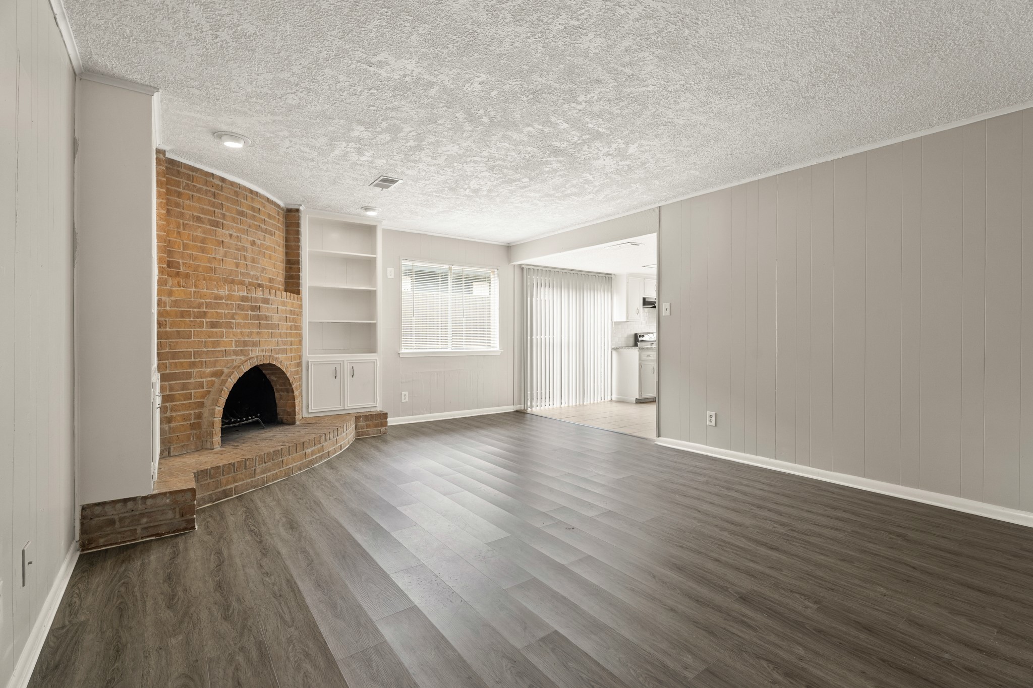 15911 Mill Point Drive Houston, TX 77059 - Photo 2 of 16 an empty room with wooden floor and fireplace