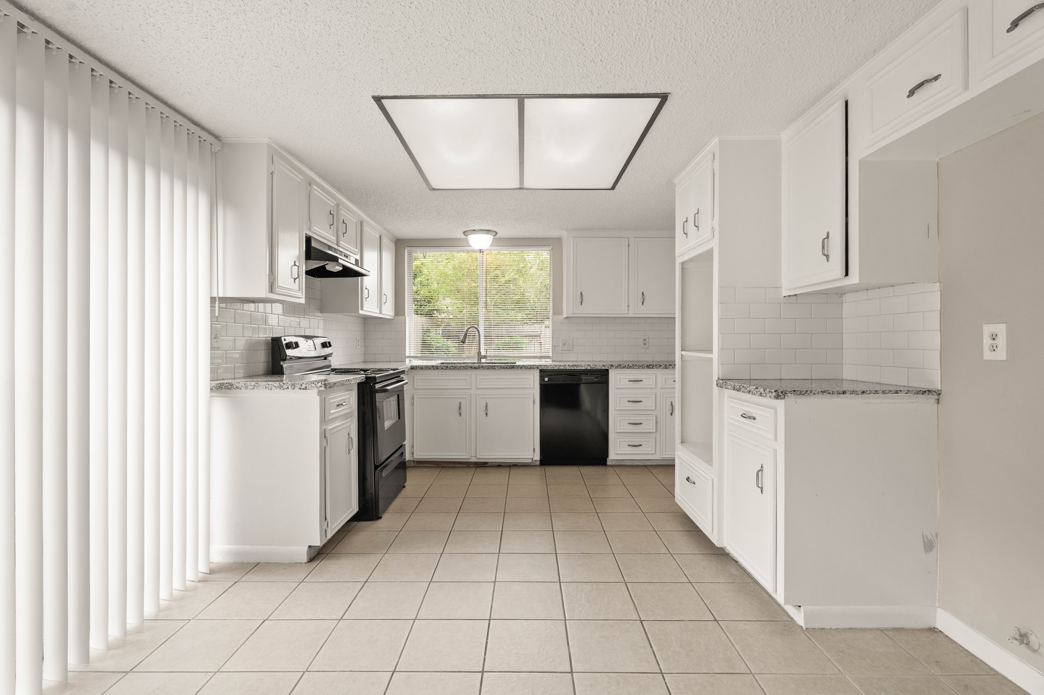 15911 Mill Point Drive Houston, TX 77059 - Photo 6 of 16 a kitchen with white cabinets and white appliances