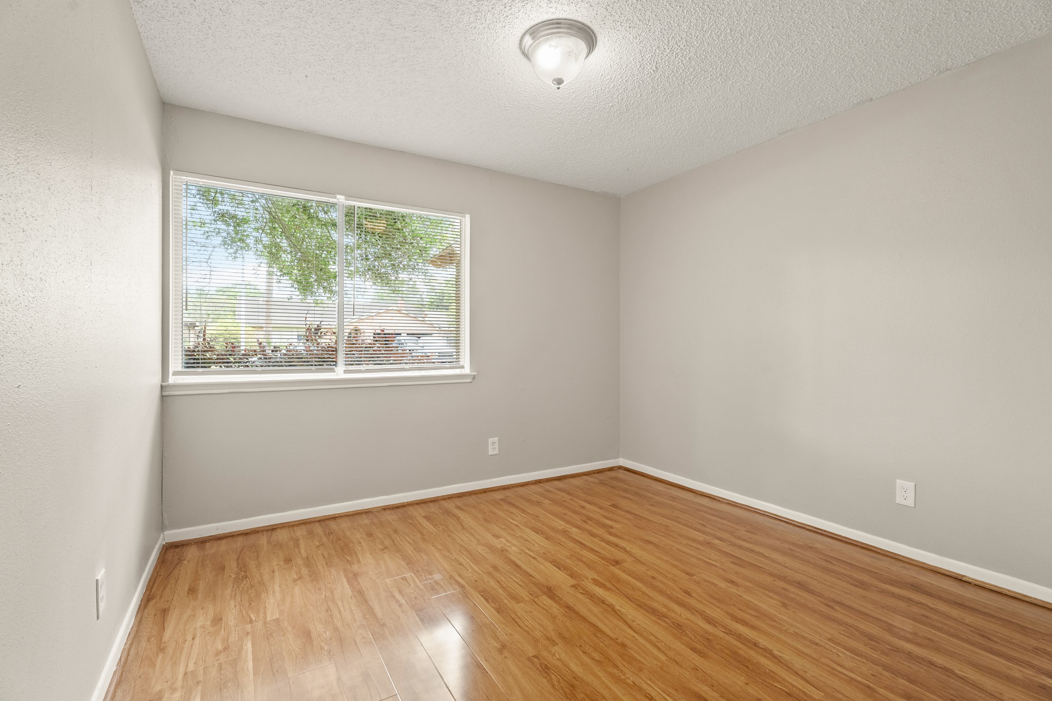 15911 Mill Point Drive Houston, TX 77059 - Photo 9 of 16 a view of an empty room with wooden floor and a window