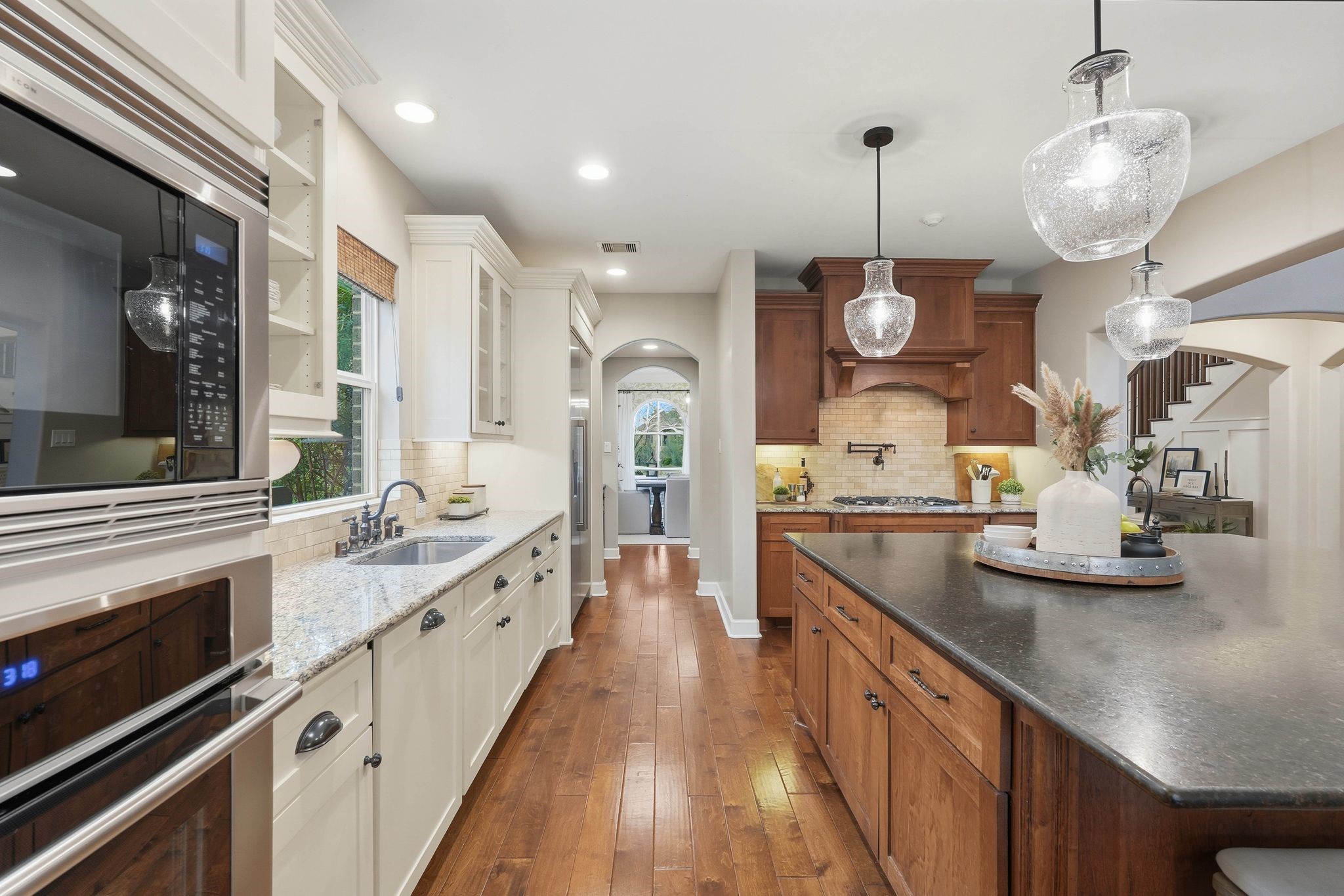 147 West Valera Ridge Place The Woodlands, TX 77389 - Photo 18 of 50 View from the breakfast area showcasing arched doorways leading to the walk-in pantry and butler’s pantry with direct access to the formal dining room.
