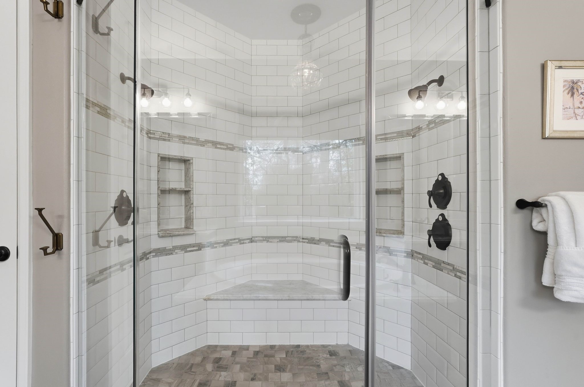 147 West Valera Ridge Place The Woodlands, TX 77389 - Photo 24 of 50 Luxurious glass-enclosed shower featuring a bench seat, dual shower controls, recessed niches, and beautiful tilework throughout.
