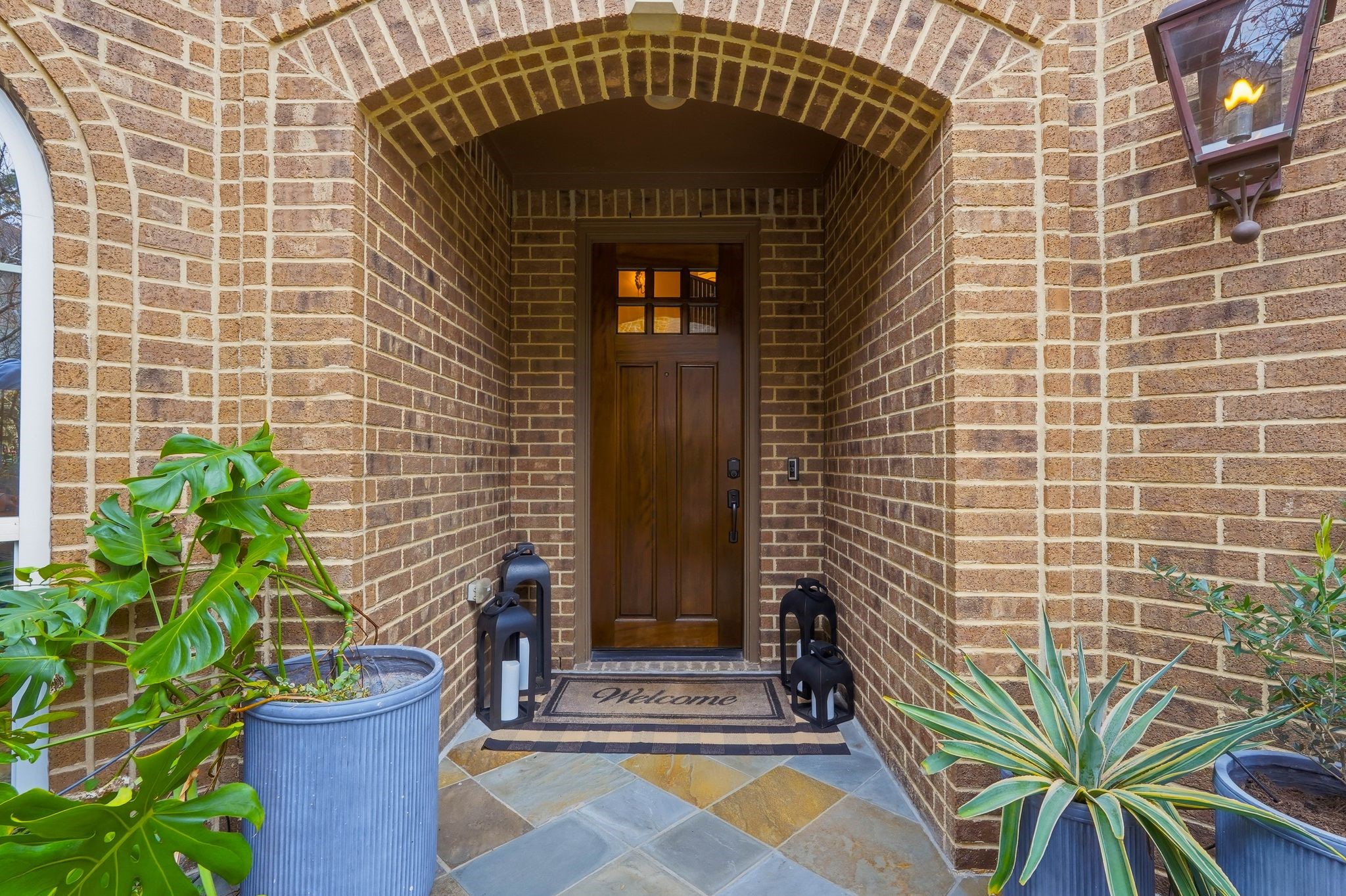147 West Valera Ridge Place The Woodlands, TX 77389 - Photo 5 of 50 Charming arched brick entry with a covered porch welcomes you home, featuring a solid wood front door, classic lantern lighting, and inviting curb appeal.