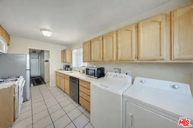 a view of a kitchen with refrigerator and cabinets