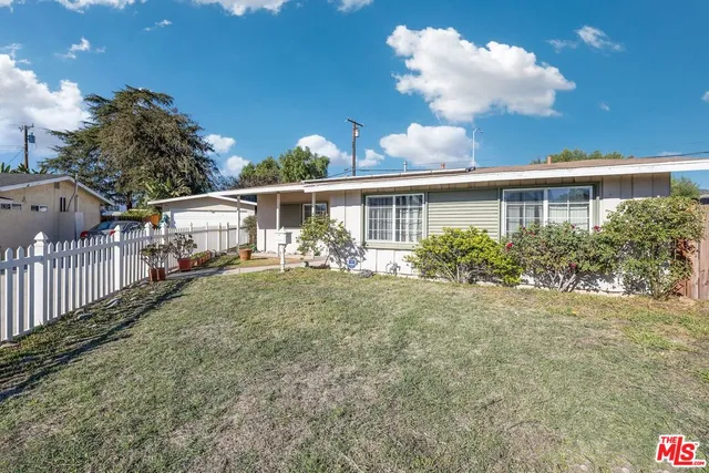 a view of a house with backyard and sitting area