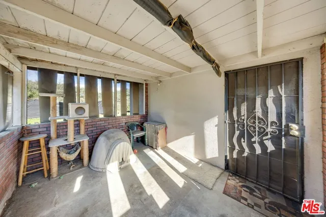a view of a porch with a table and chairs