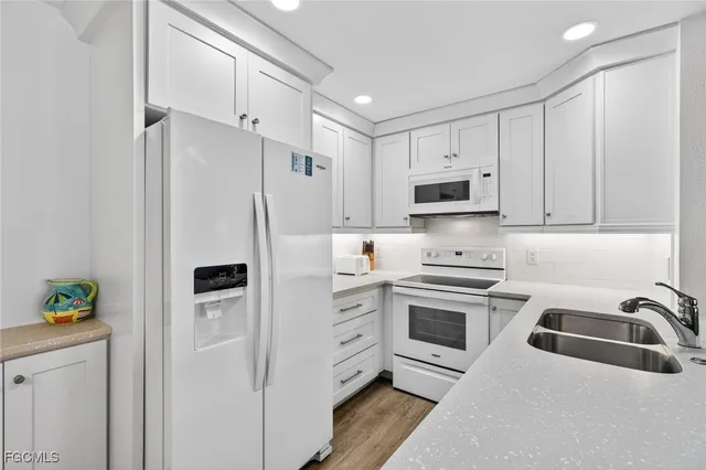 a kitchen with stainless steel appliances sink refrigerator and cabinets