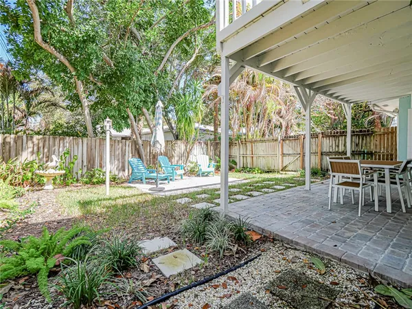 a view of a backyard with table and chairs and potted plants