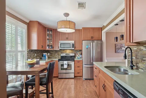 a kitchen with stainless steel appliances granite countertop a sink stove and refrigerator