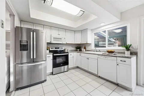 a kitchen with granite countertop a refrigerator and a sink
