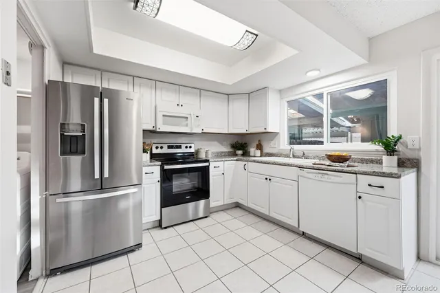 a kitchen with granite countertop a refrigerator and a sink