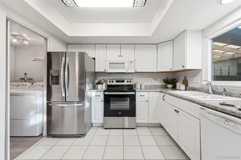 a kitchen with a refrigerator sink and cabinets