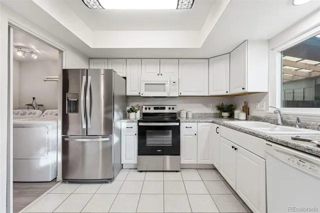 a kitchen with a refrigerator sink and cabinets