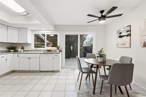 a kitchen with a dining table chairs and white cabinets