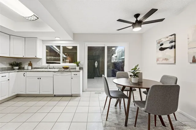 a kitchen with a dining table chairs and white cabinets