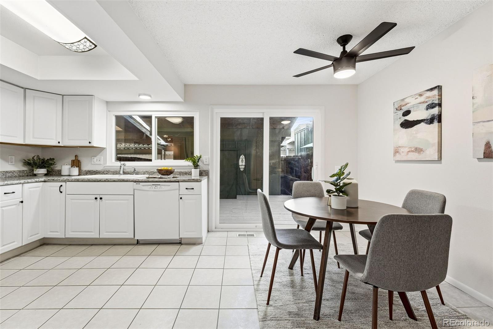 508 South Carr Street, Unit 118 Lakewood, CO 80226 - Photo 14 of 42 a kitchen with a dining table chairs and white cabinets