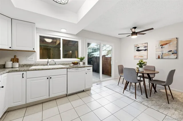 a kitchen with granite countertop cabinets a sink and chairs