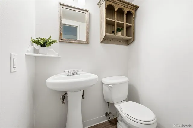 a bathroom with a sink toilet and mirror
