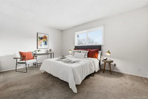 a bedroom with bed and a painting on the wall