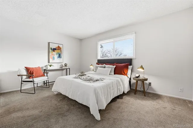 a bedroom with bed and a painting on the wall
