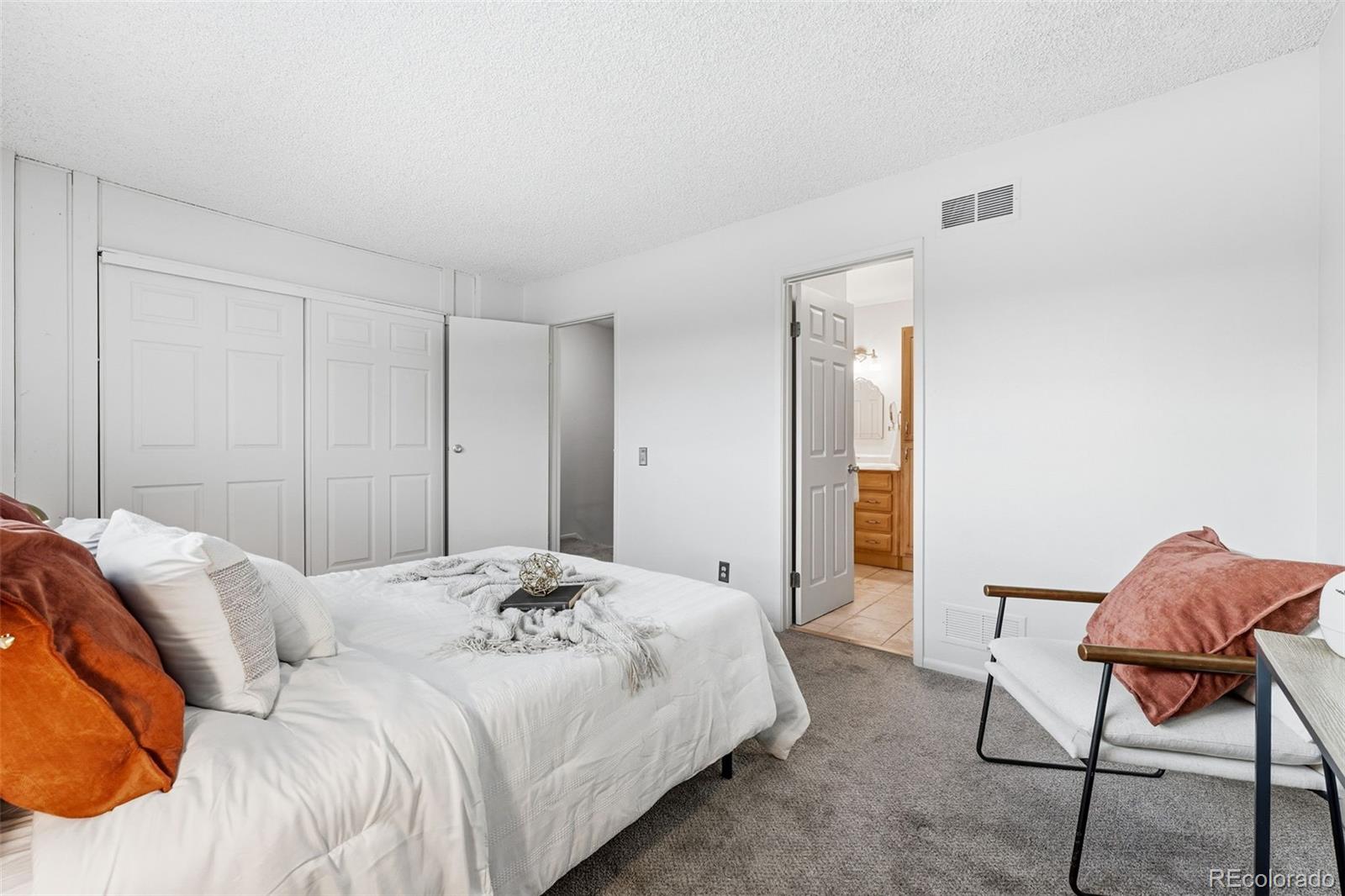 508 South Carr Street, Unit 118 Lakewood, CO 80226 - Photo 23 of 42 a bedroom with a bed and chair