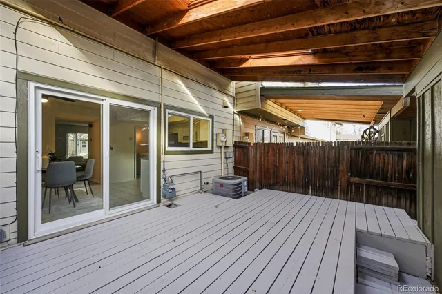 a balcony with wooden floor table and chairs