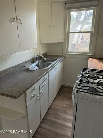 a kitchen with sink a stove and a window