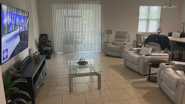 a living room with furniture a window and a kitchen view