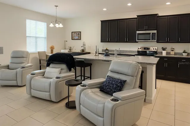 a living room with furniture a flat screen tv and a window