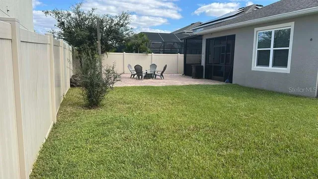 a view of a house with a big yard potted plants and large tree