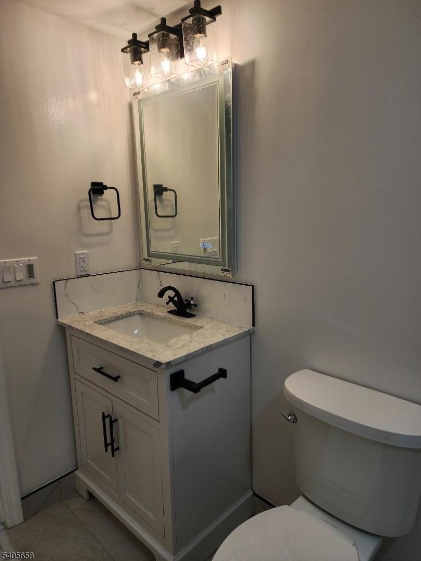 23 Old Farm Road Berkeley Heights, NJ 07922 - Photo 11 of 28 a bathroom with a granite countertop toilet sink and mirror
