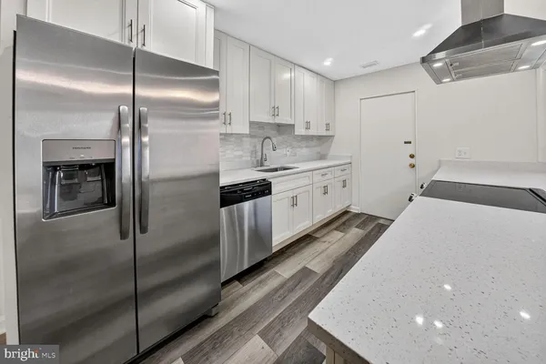a large kitchen with a refrigerator a sink and a stove